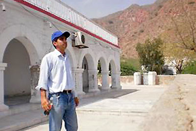 An image of a man in cap and jeans.