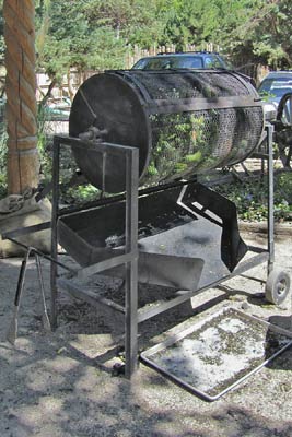 A photo of a chile roaster with tongs.