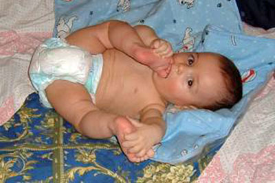 A photographic image of a baby sucking its toes.