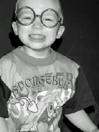 A photographic image of a boy wearing ugly glasses.