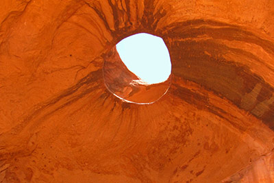 A photographic image of a hole in a rock formation in Monument Valley, Arizona.