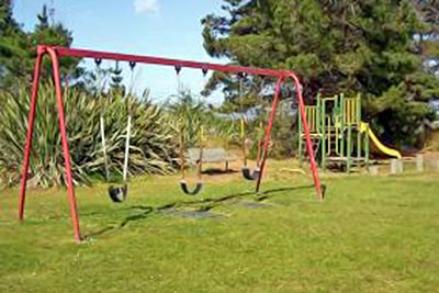 A photographic image of swings in a playground.
