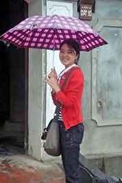A photographic image of a lady carrying an umbrella.