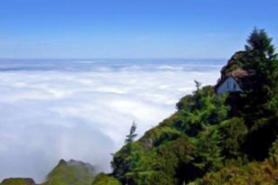 A photographic image of a mountain above a deck of clouds.