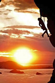 A photographic image of a free climber rising at sundown.