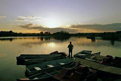 A photographic image of a man contemplating a sunset.