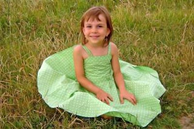 A photographic image of a little girl in a green dress.