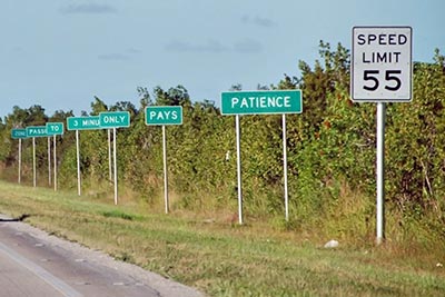 A photographic image of highway signs that emphasize patience.
