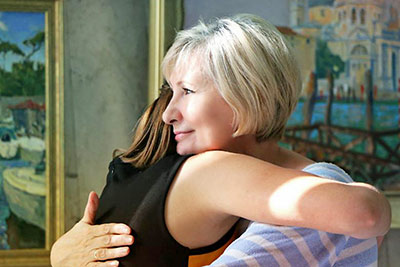 A photographic image of a woman hugging a girl.