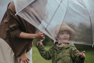 A photographic image of a mother and daughter in the rain